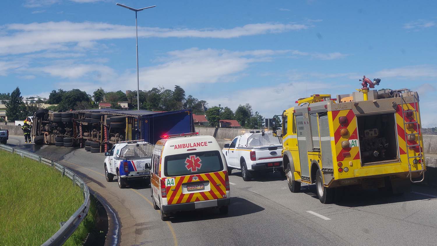 Personnel from the Eswatini National Fire, Rescue and Emergency Services assessing the damage to the truck which fell onto the road blocking the fast lane at the Mangwaneni Traffic Circle. (Pic Sibusiso Shange)